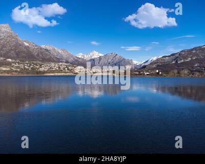 Schöne Spiegelung der Berge und Wolken im Seewasser, See Annone, Lecco, Lombardei, Italien Stockfoto