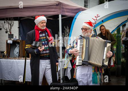 Samstag, 11. Dezember 2021 - Lymm, Hémieh, England, Vereinigtes Königreich. Das jährliche Lymm Dickensian Christmas Festival in Lymm Village kehrt nach einer Pause aufgrund von COVID 19 zurück. An diesem Tag hat es geregnet. Eine Reihe von Ständen und Händlern, die eine Vielzahl von Kunsthandwerk und Weihnachtsgeschenken verkaufen, sowie eine große Auswahl an Speisen, säumen die Dorfstraßen mit Dickenser-Charakteren in Hülle und Fülle. Es gibt auch einen Santa Dash und eine Grand Parade Credit: John Hopkins/Alamy Live News Stockfoto