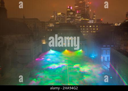 Guildhall Yard, London, Großbritannien. 11th Dez 2021. Die Borealis von der Spitze des neuen Guildhall-Flügels mit der City of London aus gesehen. Die Menschen genießen den ausverkauften Eröffnungsabend. Dan Archer's spektakuläre Borealis, eine immersive Installation, die von den Nordlichtern inspiriert wurde, erleuchtet den Himmel über dem Guildhall Yard im Herzen der City of London. Die Installation ist kostenlos, aber mit einem Ticket ausgestattet, um eine soziale Distanzierung zu gewährleisten. Es ist Teil der Winterlichtsaison der Kampagne ‘Let's Do London' des Bürgermeisters von London und kann bis zum 22nd. Dezember besichtigt werden. Kredit: Imageplotter/Alamy Live Nachrichten Stockfoto