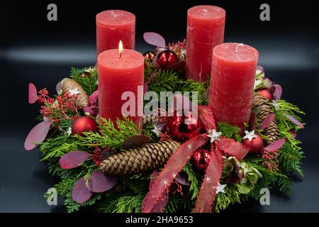 Niedrige Ansicht des schönen Adventskranzes mit einer brennenden Kerze auf schwarzem Hintergrund Stockfoto