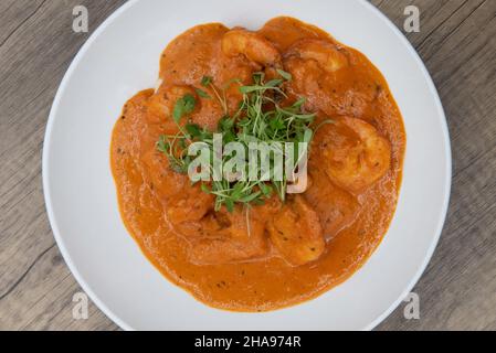 Ansicht der künstlerischen Präsentation von Garnelen in Chorizo-Sauce für eine Fusion-Mischung von Aromen in einer Mahlzeit erstickt. Stockfoto