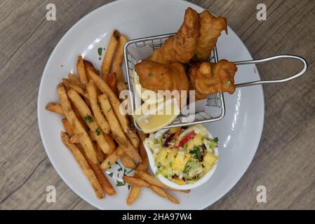 Ansicht der künstlerischen Präsentation von frittiertem Fisch und Chips als knusprige Kombination aus Meeresfrüchtegerichte. Stockfoto