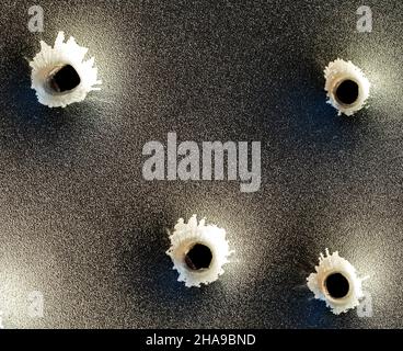 Einschusslöcher in Metall. Konzept, Einsatz von Schusswaffen. Nahaufnahme, selektiver Fokus. Stockfoto