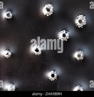 Einschusslöcher in Metall. Konzept, Einsatz von Schusswaffen. Nahaufnahme, selektiver Fokus. Stockfoto