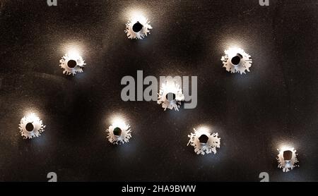 Einschusslöcher in Metall. Konzept, Einsatz von Schusswaffen. Nahaufnahme, selektiver Fokus. Stockfoto