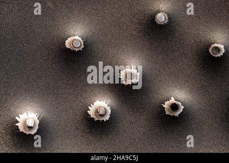 Einschusslöcher in Metall. Konzept, Einsatz von Schusswaffen. Nahaufnahme, selektiver Fokus. Stockfoto