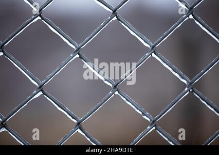 Metall alten rostigen Mesh mit Eis bedeckt. Verschlechternde Wetterbedingungen. Stockfoto