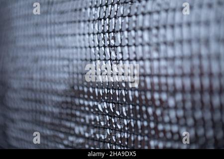 Metall alten rostigen Mesh mit Eis bedeckt. Verschlechternde Wetterbedingungen. Stockfoto