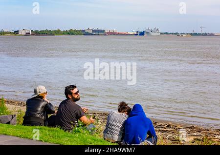 Am Ufer des Mississippi River im Woldenberg Riverfront Park, 15. November 2015, in New Orleans, Louisiana, sitzen Menschen. Stockfoto