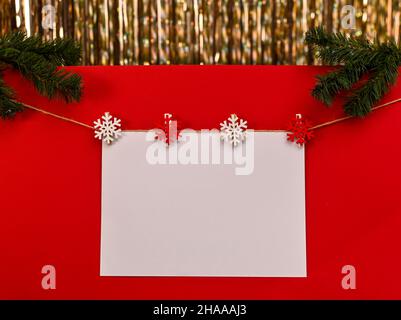 Ein weißes Blatt für die Inschrift zu Weihnachten auf rotem Hintergrund Stockfoto
