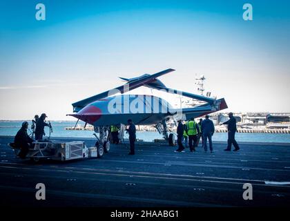 Matrosen und Boeing-Teammitglieder bereiten sich darauf vor, ein unbemanntes Boeing-Flugzeug der MQ-25 an Bord des Flugzeugträgers USS George H.W. in die Hangarbucht zu bringen Buchse (CVN 77). Die MQ-25 wird das weltweit erste operationelle, Carrier-basierte unbemannte Flugzeug sein und ist integraler Bestandteil des zukünftigen Carrier Air Wing (CVW). Es wird eine Luftbetankungskapazität bereitstellen, die die Reichweite, die Einsatzfähigkeit und die Letalität der CVW- und Carrier Strike Group (CSG) erweitert. GHWB bietet der nationalen Kommandobehörde flexible, anpassungsfähige Kriegskampfkapazitäten durch die Trägerstreikgruppe, die maritimes Stabilisierungsthauf beibehält Stockfoto