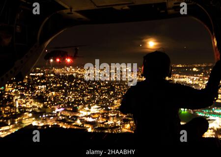 Soldaten der US-Armee, die dem 96th Aviation Truppenkommando der Washington Army National Guard zugewiesen wurden, halten sich am 21. November 2021 über der Skyline von Seattle auf. Die Flugzeugcrew war Teil einer Überführung mehrerer Schiffe beim Fußballspiel Seattle Seahawks gegen die Arizona Cardinals. (USA Foto der Armee-Nationalgarde von Sgt. Adeline Witherspoon) Stockfoto