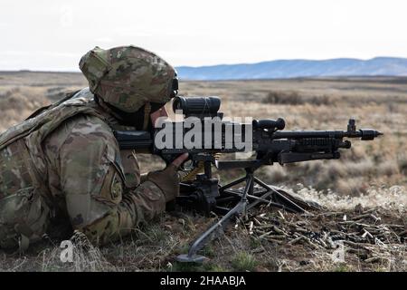 Ein Soldat der Chosin Company, 1st Bataillon, 17th Infanterie-Regiment, 2nd Stryker Brigade Combat Team, 7th Infanterie-Division, zieht während der Trainingsübung Rising Thunder am 10. Dezember 2021 im Yakima Training Center, Wa, Sicherheitskräfte mit einem M240B an. Stockfoto