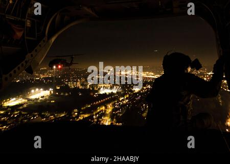 Soldaten der US-Armee, die dem 96th Aviation Truppenkommando der Washington Army National Guard zugewiesen wurden, halten sich am 21. November 2021 über der Skyline von Seattle auf. Die Flugzeugcrew war Teil einer Überführung mehrerer Schiffe beim Fußballspiel Seattle Seahawks gegen die Arizona Cardinals. (USA Foto der Armee-Nationalgarde von Sgt. Adeline Witherspoon) Stockfoto