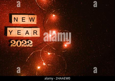 Neujahr 2022. Holzbuchstaben auf Blöcken. Auf rotem Hintergrund