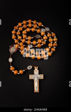Traditionelle christliche heilige religiöse hölzerne Rosenkranz isoliert auf schwarzem Hintergrund. Stockfoto