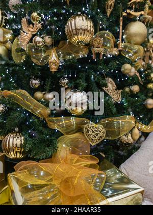 Weihnachtsbaum-Detail mit goldener Weihnachtskugel. Weihnachtsbaum Lichter und Dekorationen. Selektiver Fokus, Niemand, Straßenansicht, Konzeptfoto Stockfoto