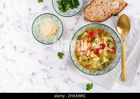 Minestrone, italienische Gemüsesuppe mit Pasta auf hellem Tisch. Draufsicht, flach liegend Stockfoto