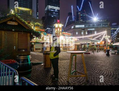 12. Dezember 2021, Hessen, Frankfurt/Main: Am frühen Morgen steht ein Wachmann am Eingang des ansonsten noch menschenleeren Frankfurter Weihnachtsmarktes, der nur nach der Regel von 2G betreten werden darf. Foto: Frank Rumpenhorst/dpa Stockfoto