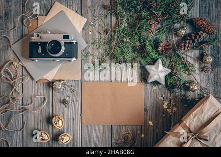 Flacher Weihnachtshintergrund mit Retro-Kamera und Buchstaben. Stockfoto