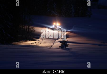 Bad Hindelang, Deutschland. 12th Dez 2021. Kurz vor Sonnenaufgang fährt ein Langlauffahrzeug auf der Loipe im Stadtteil Unterjoch. Quelle: Karl-Josef Hildenbrand/dpa/Alamy Live News Stockfoto