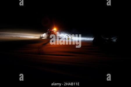 Bad Hindelang, Deutschland. 12th Dez 2021. Kurz vor Sonnenaufgang fährt ein Langlauffahrzeug auf der Loipe im Stadtteil Unterjoch. Quelle: Karl-Josef Hildenbrand/dpa/Alamy Live News Stockfoto