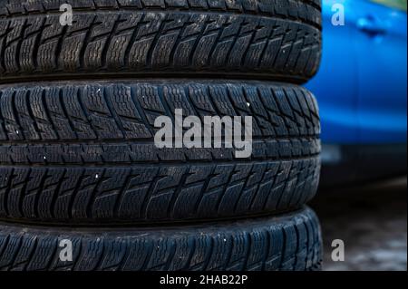 Winterreifen neben dem Auto im Radservice, saisonales Reifenwechselkonzept, Nahaufnahme Stockfoto