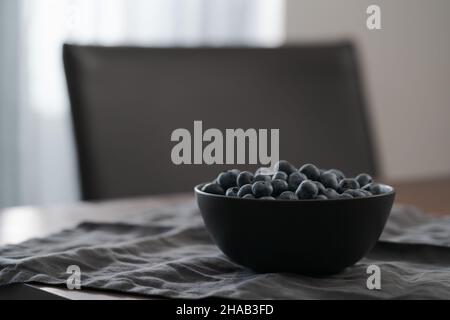 Große Schüssel mit Heidelbeeren auf dem Tisch, flacher Fokus Stockfoto