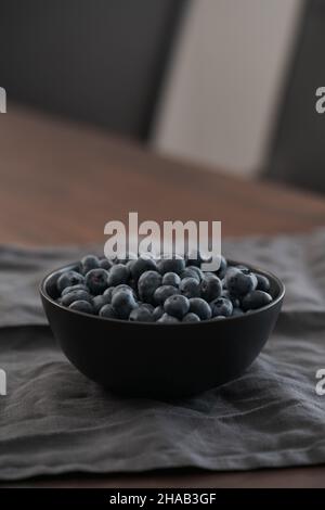Große Schüssel mit Heidelbeeren auf dem Tisch, flacher Fokus Stockfoto