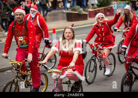 London, Großbritannien. 11th Dez 2021. Die als Weihnachtsmann gekleideten Menschen sahen entlang der Regent Street in London radeln. Kredit: SOPA Images Limited/Alamy Live Nachrichten Stockfoto