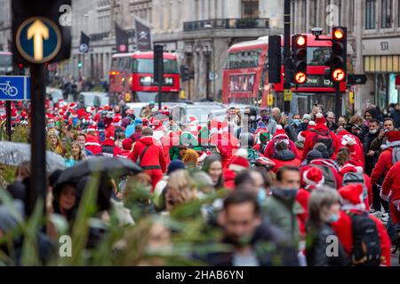 London, Großbritannien. 11th Dez 2021. Die als Weihnachtsmann gekleideten Menschen sahen entlang der Regent Street in London radeln. Kredit: SOPA Images Limited/Alamy Live Nachrichten Stockfoto