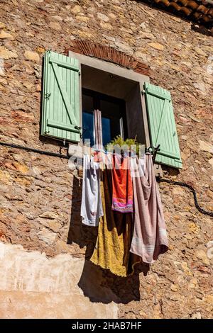 Kleidung, die in der Sonne auf einem Hausbalkon in Cessenon Sur Orb, Frankreich, trocknet Stockfoto
