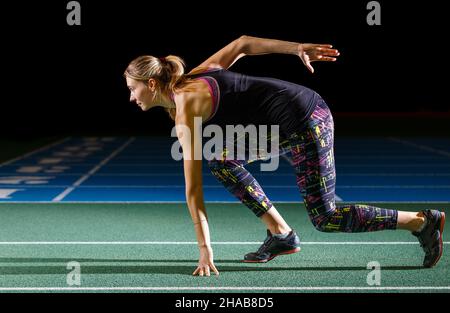 Junge weibliche Weitsprung-Sportlerin trainiert auf der Leichtathletik-Arena Stockfoto