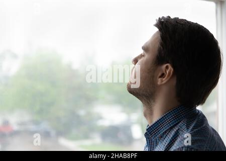 Junger Mann schloss die Augen Pose auf Fensterhintergrund Stockfoto