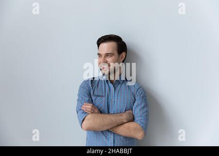 Junger Mann in legerem Hemd posiert auf grauem Studiohintergrund Stockfoto