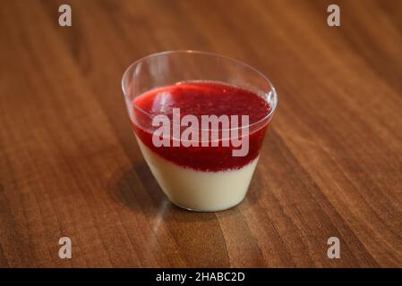 Köstliches italienisches Dessert Panna Cotta mit Himbeer-Coulis in kleinen transparenten Gläsern Stockfoto