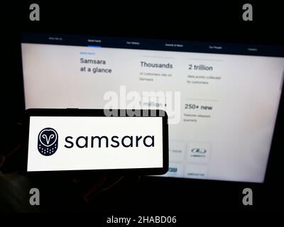 Person, die Mobiltelefon mit dem Logo des US-Cloud-Softwareunternehmens Samsara Inc. Auf dem Bildschirm vor der Business-Webseite hält. Konzentrieren Sie sich auf die Telefonanzeige. Stockfoto