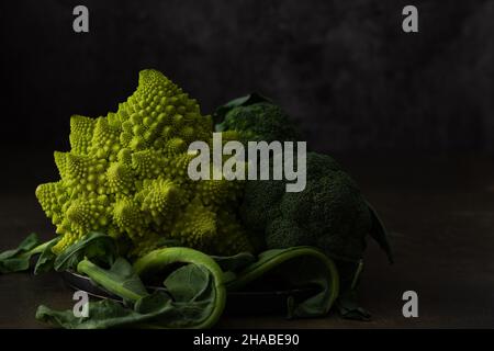 Romanesco Kohl und Brokkoli Nahaufnahme auf dunklem Hintergrund Stockfoto