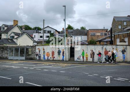 Eine Bushaltestelle mit einem Wandgemälde, auf dem die Menschen vor Ort, die auf einen Bus warten, Builth Wells, Powys, Wales, abgebildet sind Stockfoto