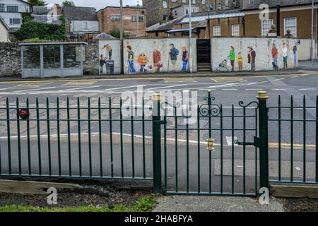 Eine Bushaltestelle mit einem Wandgemälde, auf dem die Menschen vor Ort, die auf einen Bus warten, Builth Wells, Powys, Wales, abgebildet sind Stockfoto