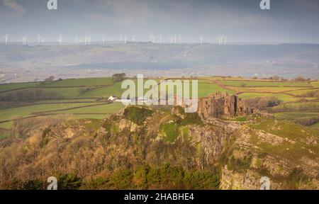 Windturbinen am Horizont mit Blick auf das Schloss Carreg Cennen in der Nähe des Dorfes Trapp in Carmarthenshire, South Wales, Großbritannien Stockfoto