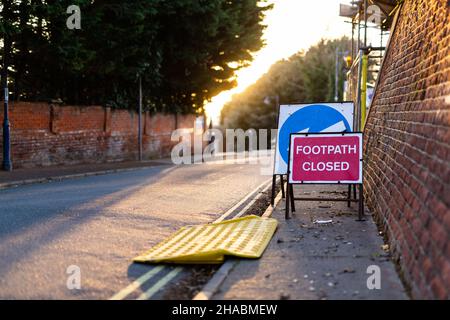 Schild „Fußweg geschlossen“ und eine temporäre Rollstuhlrampe, die die Öffentlichkeit über die vor uns liegende Schließung informiert Stockfoto