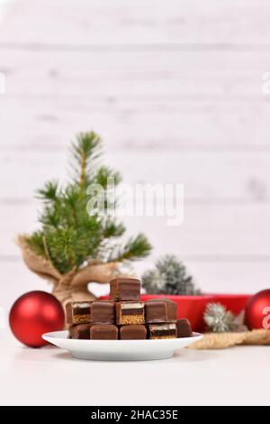 Traditionelle deutsche Süßwaren, genannt 'Dominosteine'. Weihnachtsbonbons bestehend aus Lebkuchen, Gelee und Marzipan-Schichten, die mit Schokoladenvereisung überzogen sind Stockfoto