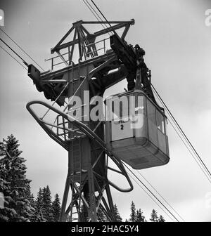 Zakopane, 1969-12-03. Przed zimowym sezonem narciarskim 1969/1970, przeprowadzono okresowy remont kolei linowej na Kasprowy Wierch. Dokonano wymiany liny noœnej na odcinku KuŸnice - Myœlenickie Turnie. NZ. Wagonik kolei linewej na wyremontowanym odcinku trasy doje¿d¿a od stacji pocz¹tkowej w zakopiañskich KuŸnicach. mta PAP/Tadeusz Olszewski Zakopane, 3. Dezember 1969. Renovierte Seilbahn-Linie vor der Skisaison 1969/1970. Der Catenarian auf Kuznice - Myslenickie Turnie Route wurde geändert. Im Bild: Zugänge mit der Seilbahn zum Bahnhof Kuznice. mta PAP/Tadeusz Olszewski Stockfoto