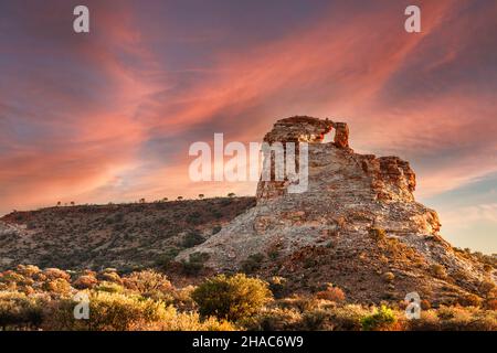 Landschaft bei Sonnenuntergang im Outback Northern Territory mit Nahaufnahme des Window Rock im Chambers Pillar Historical Reserve mit Hintergrund des Himmels Stockfoto