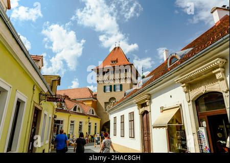 KOSZEG, UNGARN - 14. AUGUST 2021: An einem sonnigen Tag steht in Koszeg der Heldenturm mit Tourits. Stockfoto