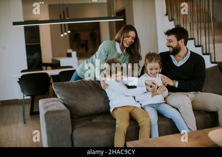 Niedliche Geschwister kämpfen zu Hause um die Fernbedienung des Fernsehers Stockfoto