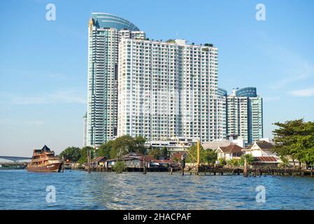 BANGKOK, THAILAND - 01. JANUAR 2019: Moderne mehrstöckige Wohnanlage am Ufer des Chao Phraya Flusses an einem sonnigen Tag Stockfoto