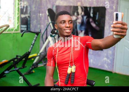 Gutaussehender Sportbegeisterter beim Selfie im Fitnessstudio Stockfoto