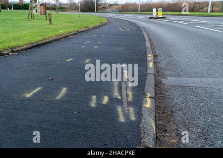 Newhame Rd, Montrose, Angus, Schottland, 12th vom 2021. Dezember: Bild: Die Nachwirkungen eines ernsthaften RTC, bei dem eine Hündin getötet wurde, als ein Auto die Kontrolle über die scharfe Kurve der Newhame Rd verlor, den Straßenbelag aufbog, die Hündin-Geherin schlug und dann in den Bahndamm stürzte. Der tödliche RTC ereignete sich um 8,20pm Uhr am Samstag, dem 11th. Dezember 2021. Gelbe Markierungen auf der Straße stammen von der Polizei und veranschaulichen den Weg, den das Auto eingeschlagen hat. Mitglieder der Öffentlichkeit wurden gesehen, um Blumen in einem Zeichen des Respekts für die Frau zu legen, die starb.Quelle:Barry Nixon/Alamy Live News Stockfoto